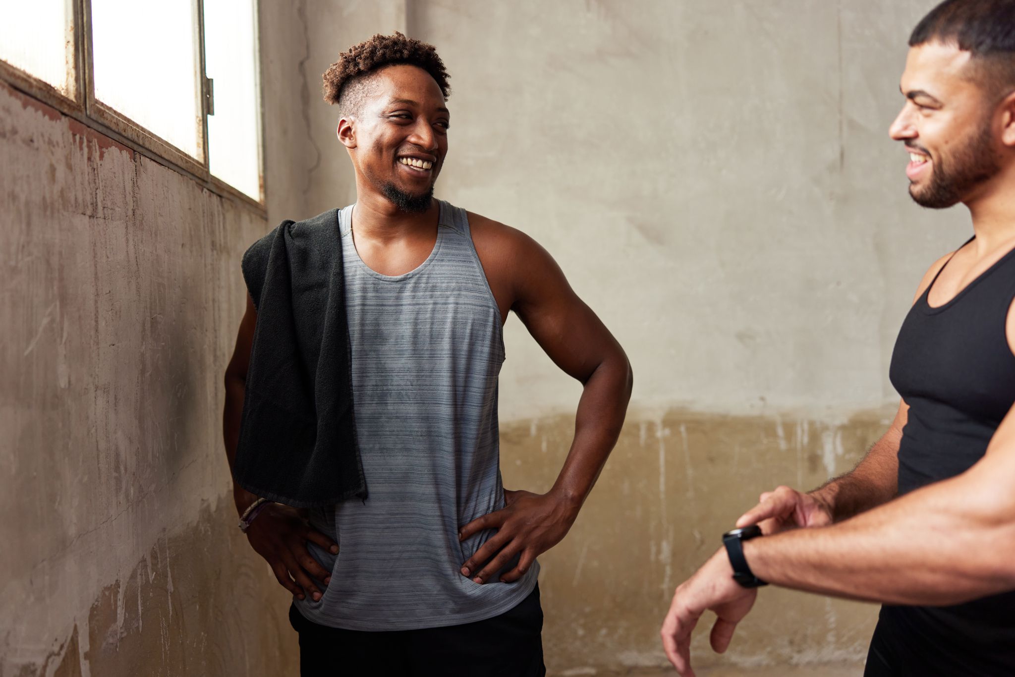 Hombres conversando y sonriendo en el gimnasio.