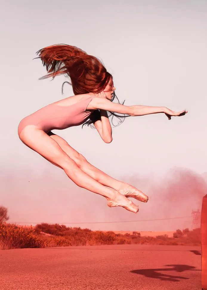 Bailarina saltando en el aire al atardecer
