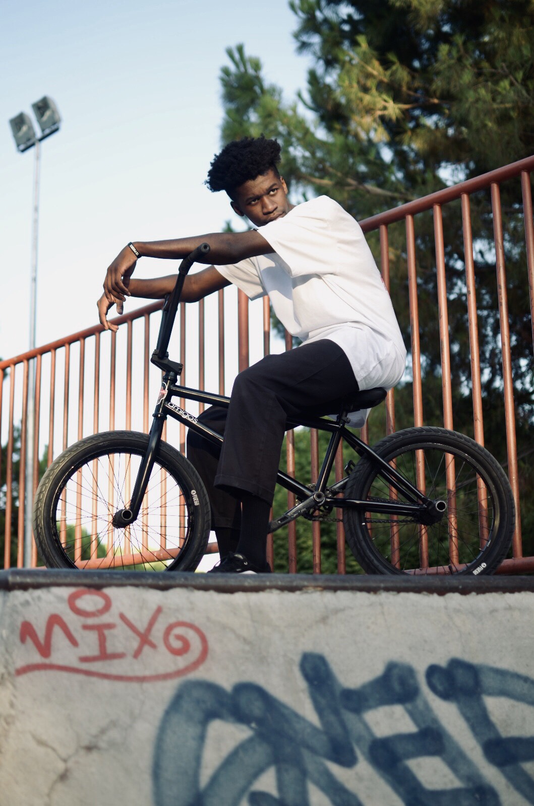 Person on BMX bike at skate park ramp.