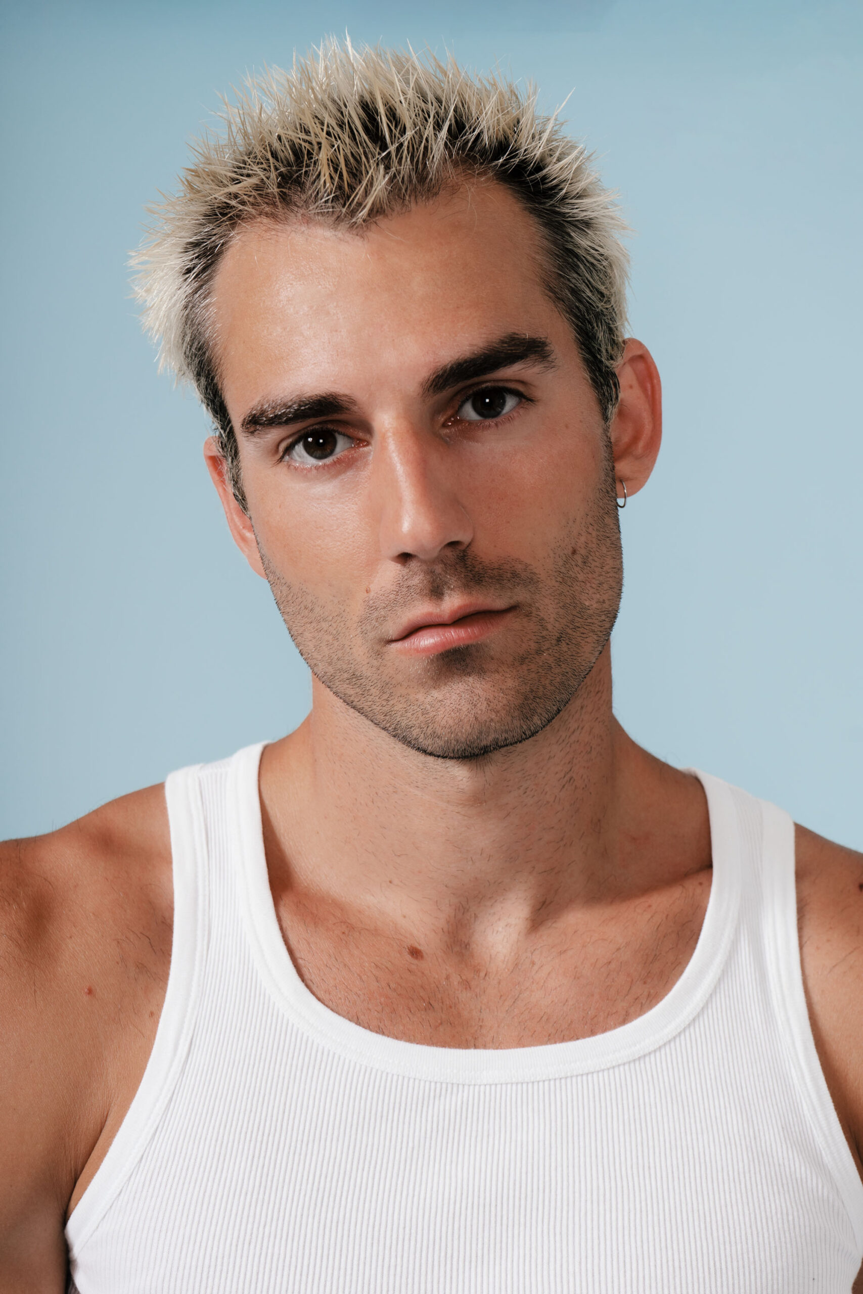 Man in white tank top with spiky hair