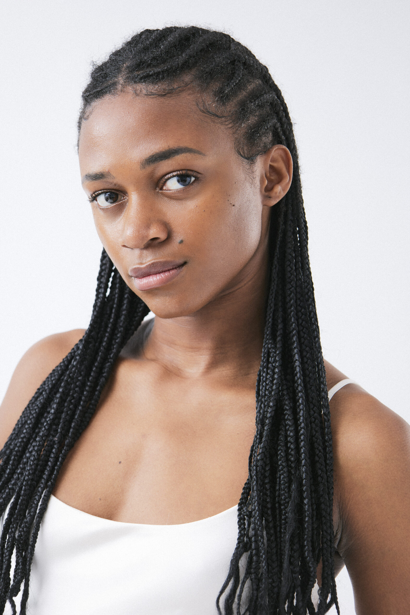 Person with long braided hair in white top