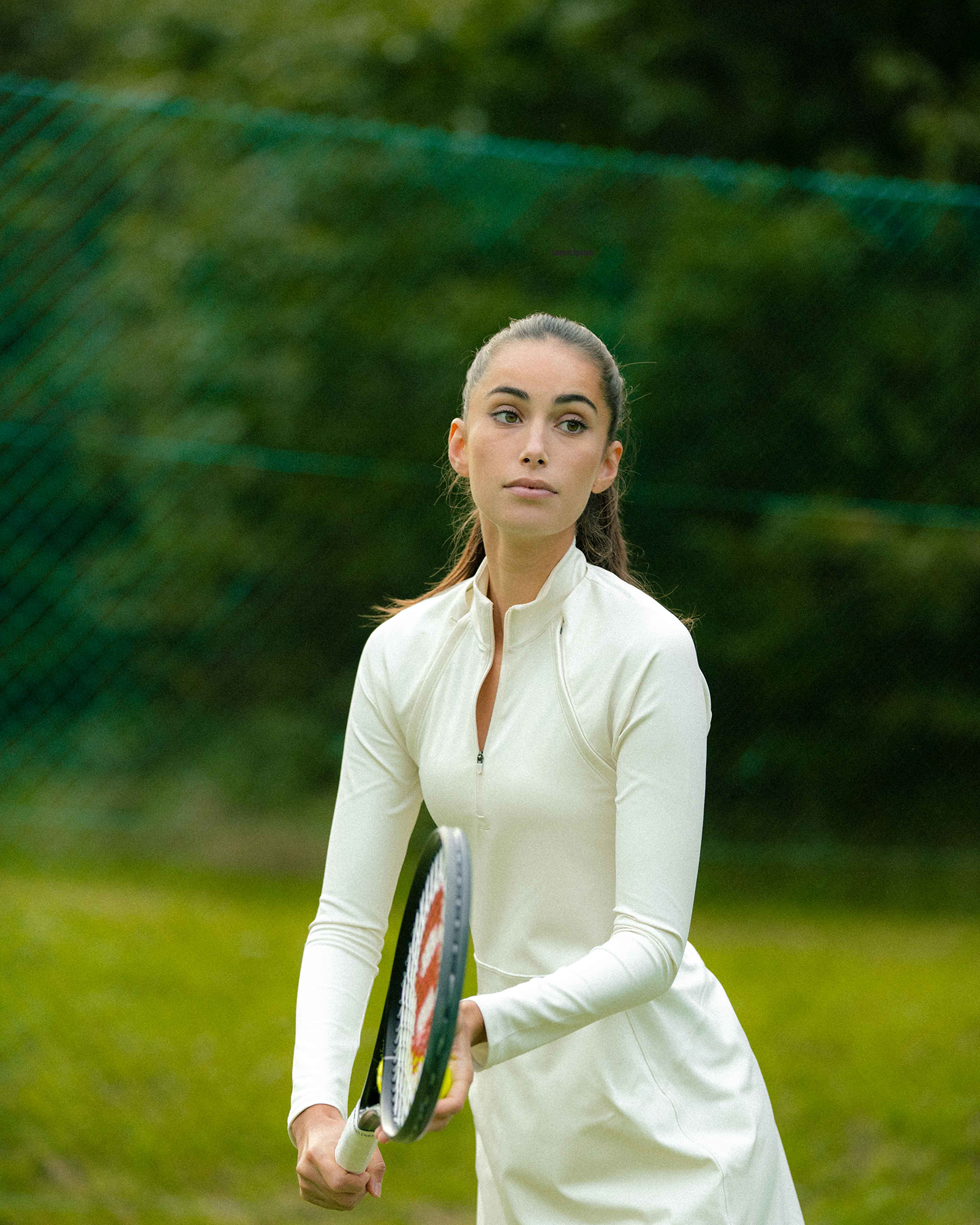 Woman playing tennis in white outfit.