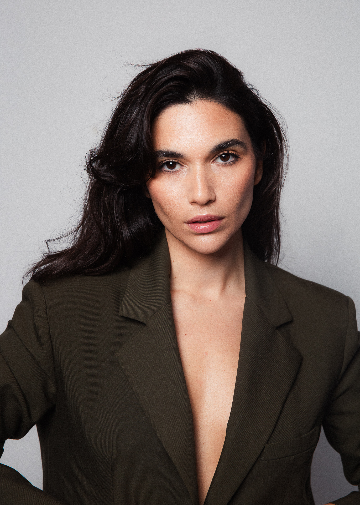 Person in dark blazer, neutral background.