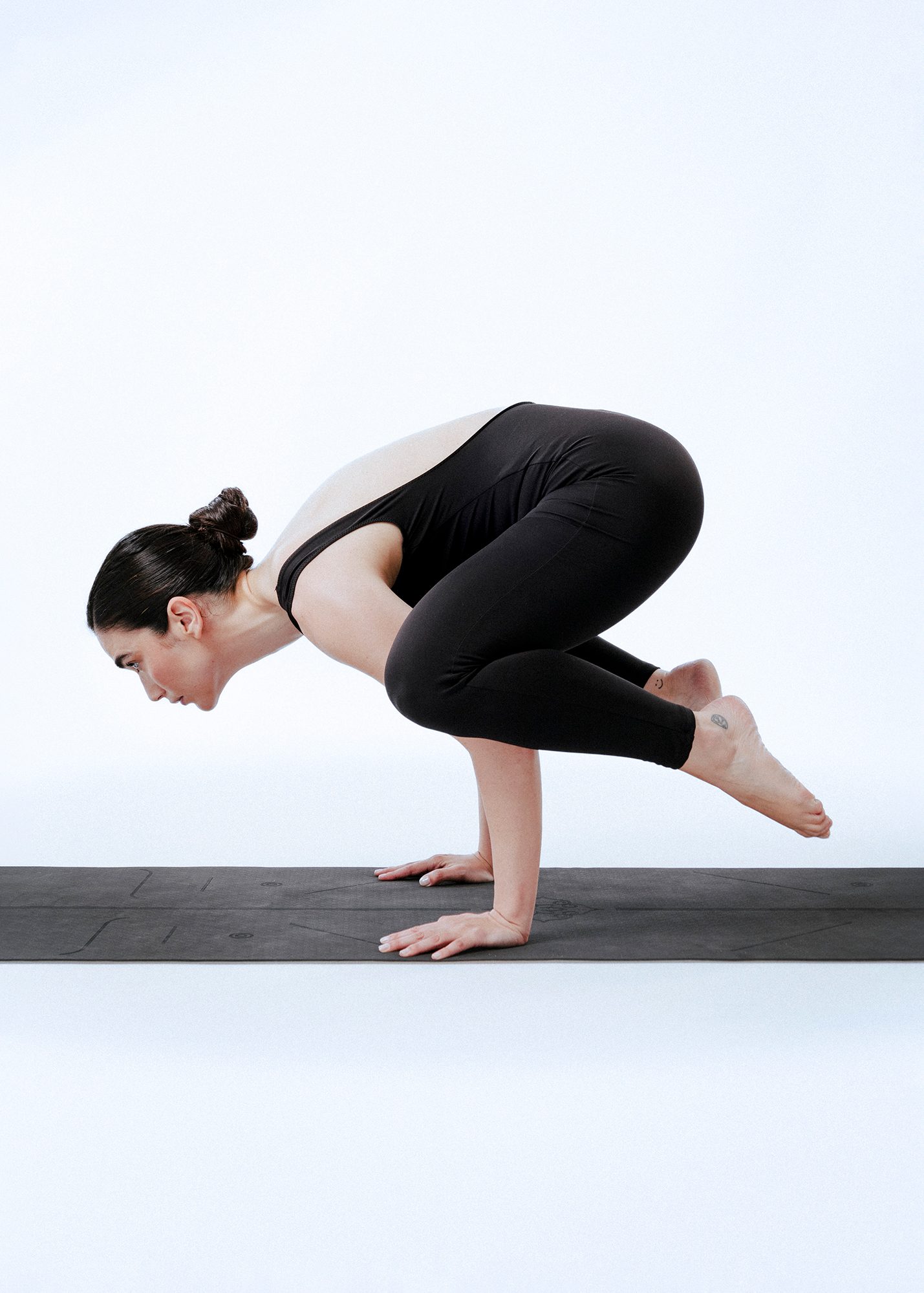 Woman practicing Crow Pose yoga position