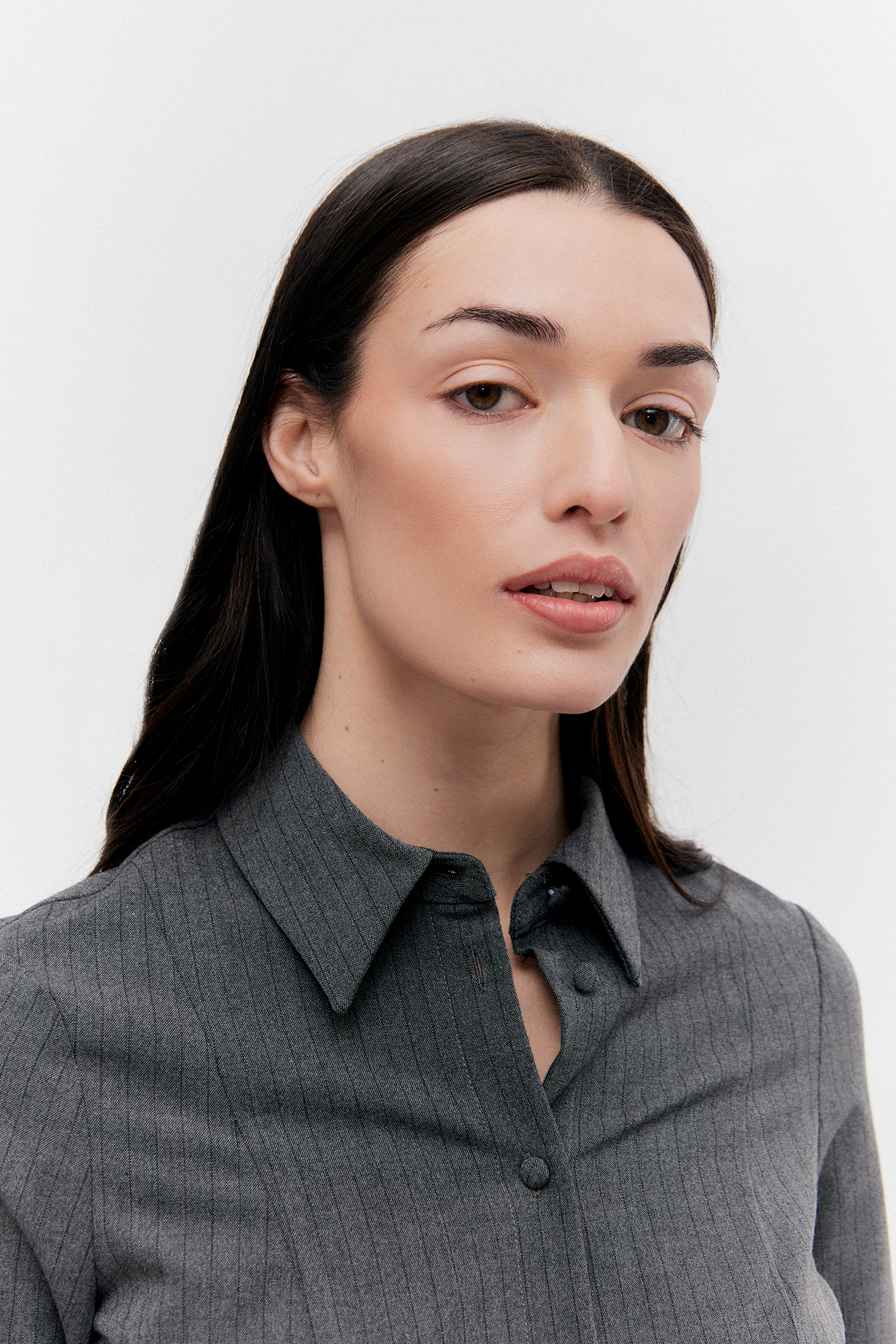 Person wearing gray pinstripe shirt, looking at camera.