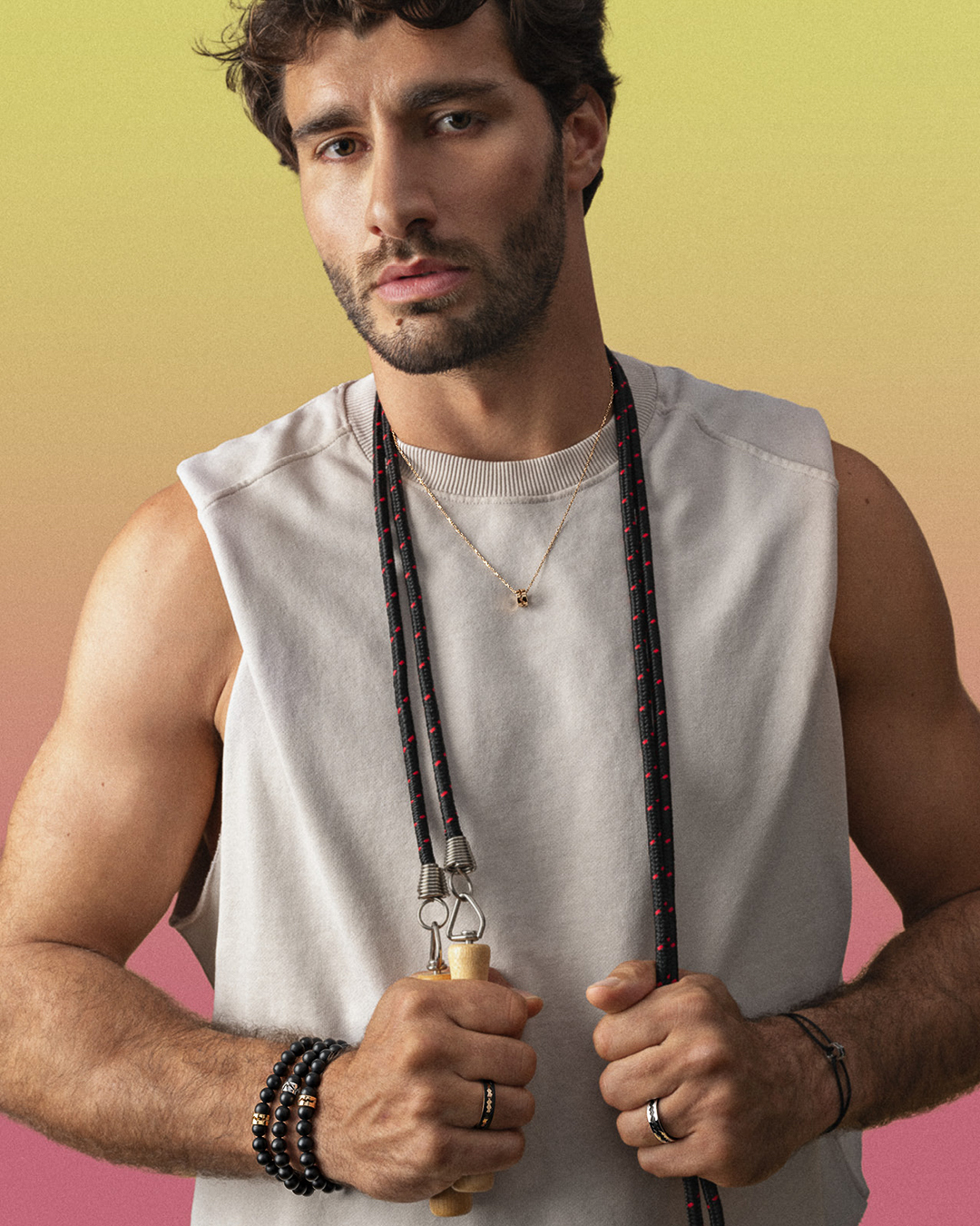 Man holding jump rope, wearing casual tank top.