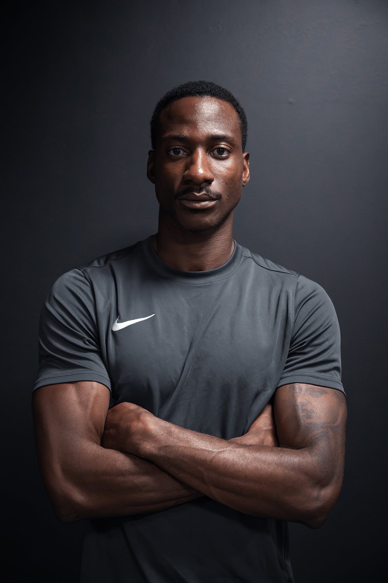 Man in athletic wear crossing arms confidently.