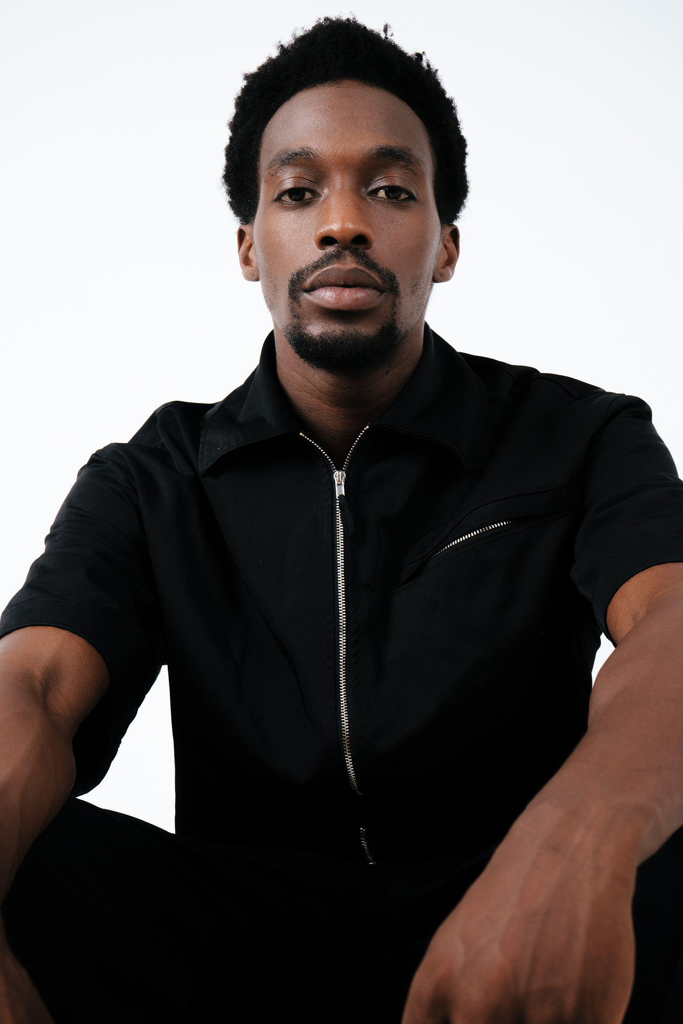 Person in black outfit looking at camera