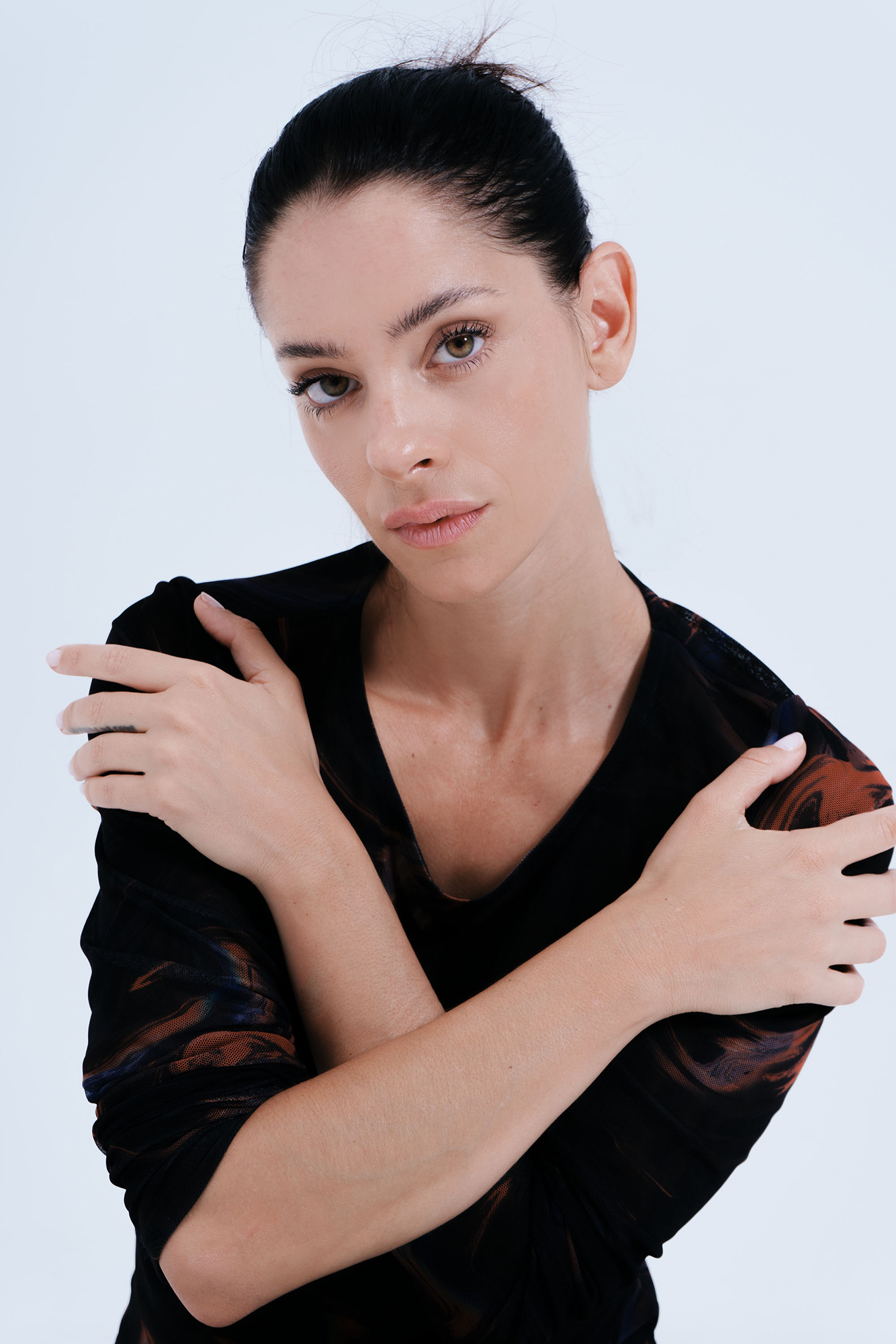 Woman posing with arms crossed, serious expression
