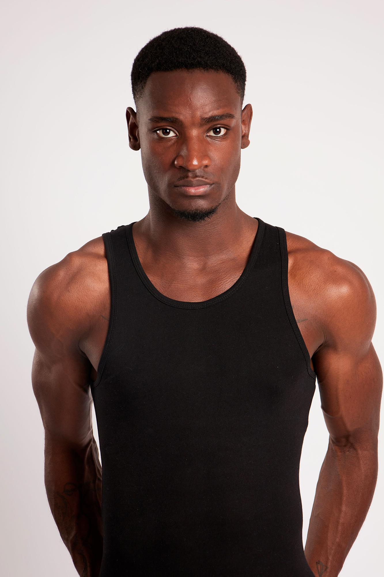 Man wearing black tank top, studio portrait