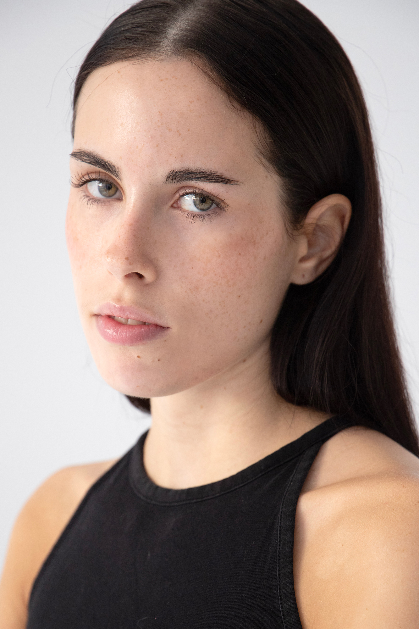 Person with long hair in black tank top.