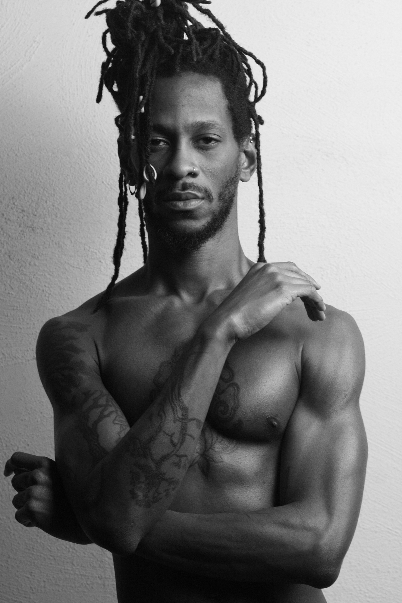 Man with dreadlocks and tattoos, monochrome portrait