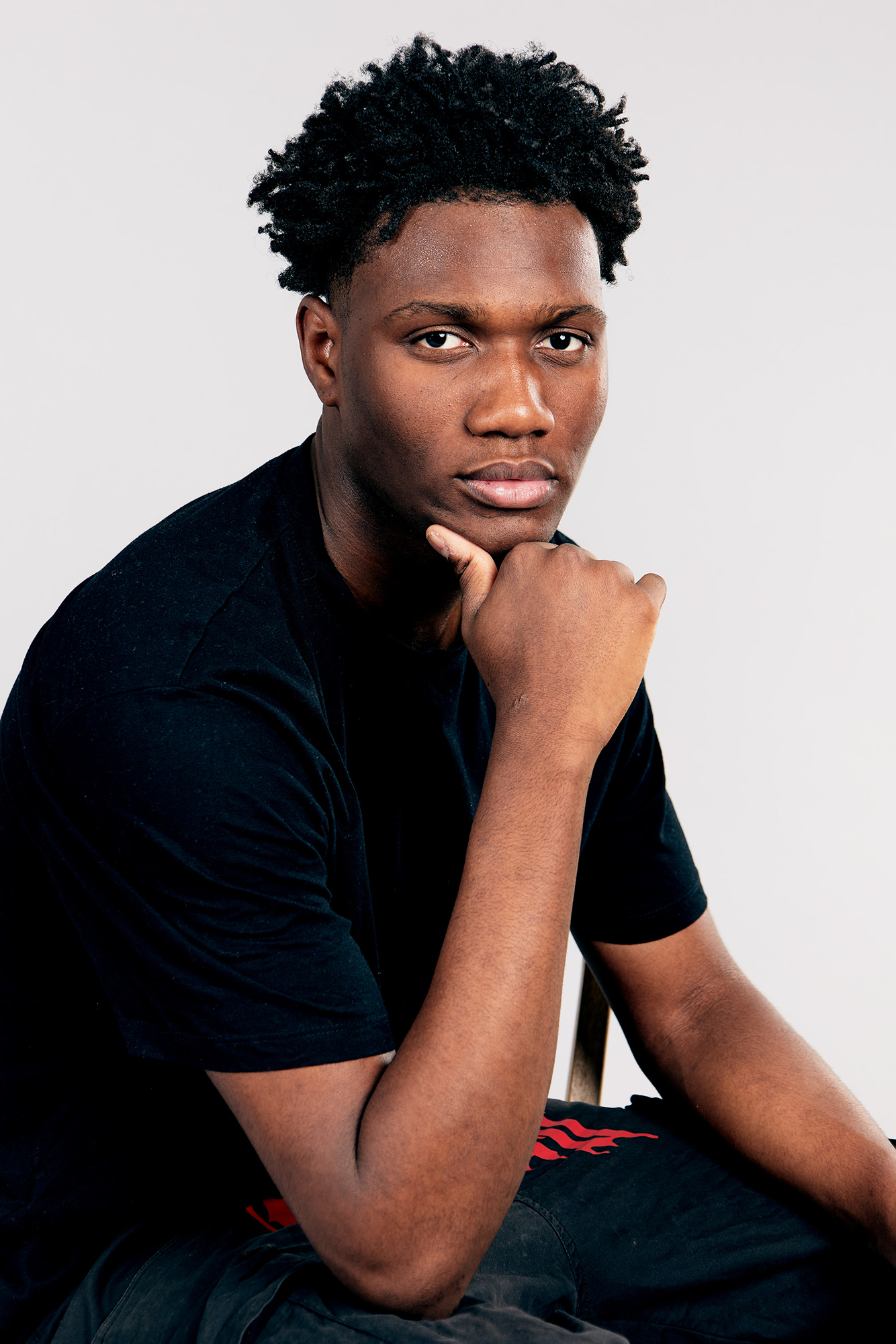 Portrait of a thoughtful young man, hand on chin.