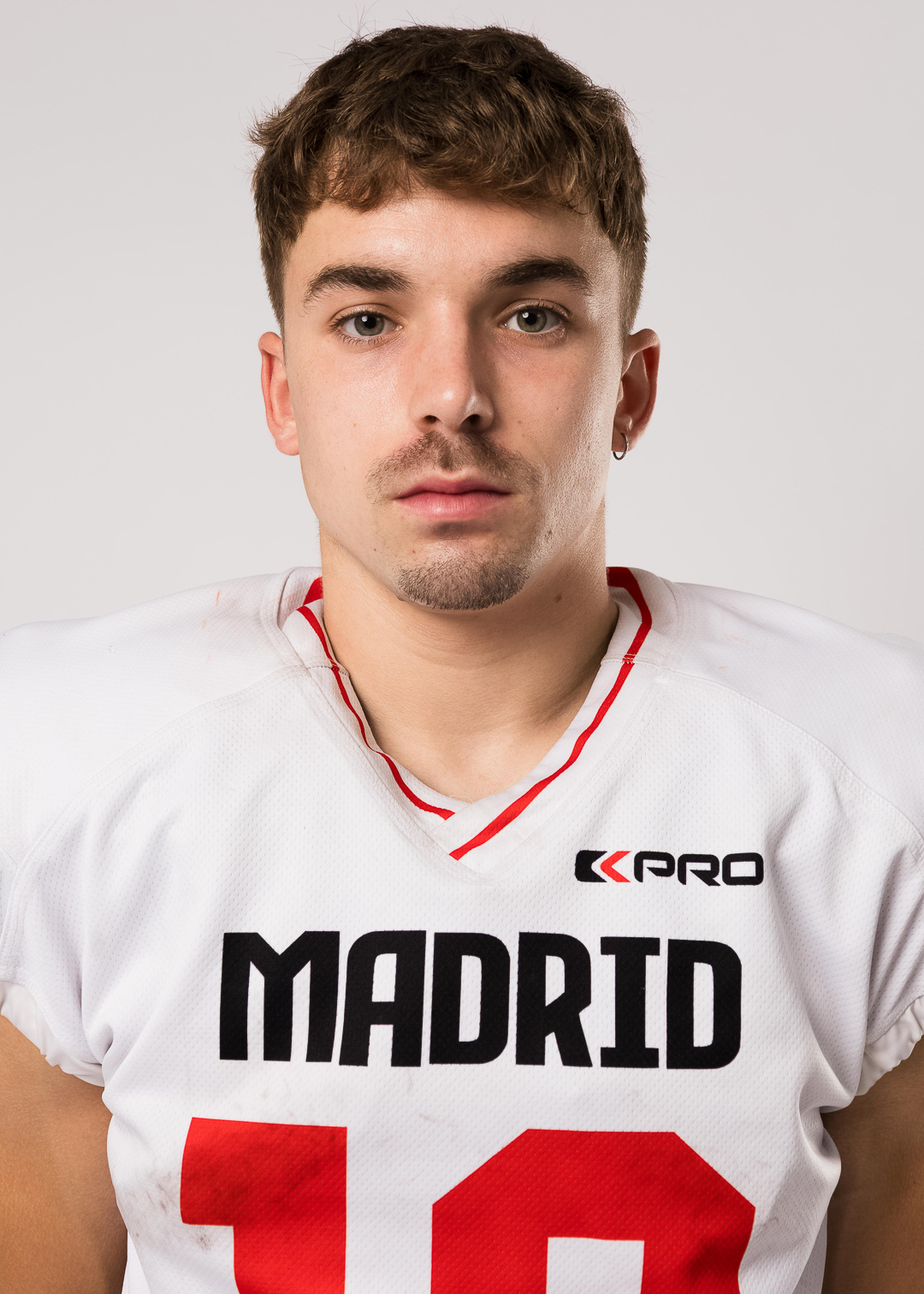 Football player in Madrid jersey, posing confidently.