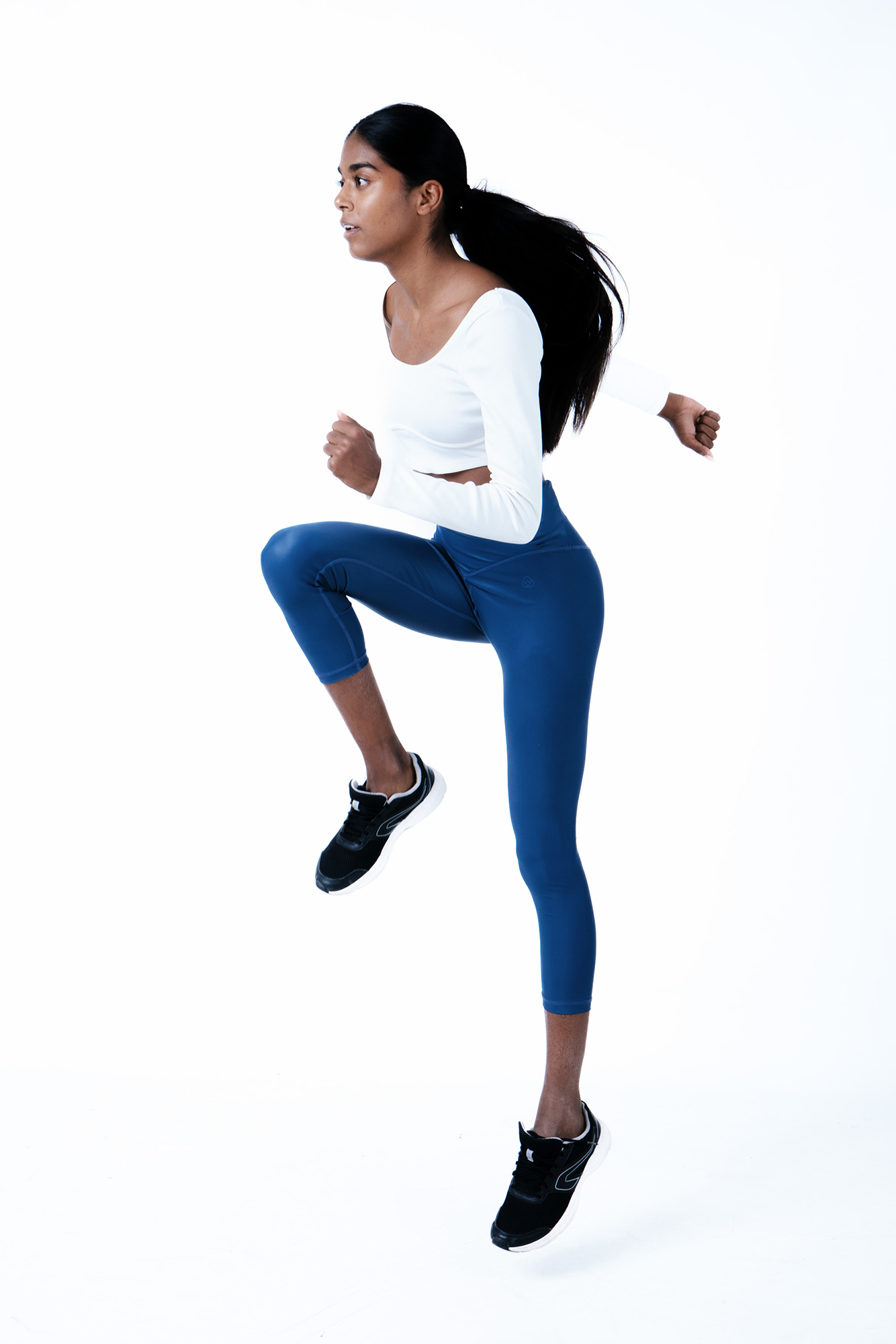 Woman in athletic pose, white background