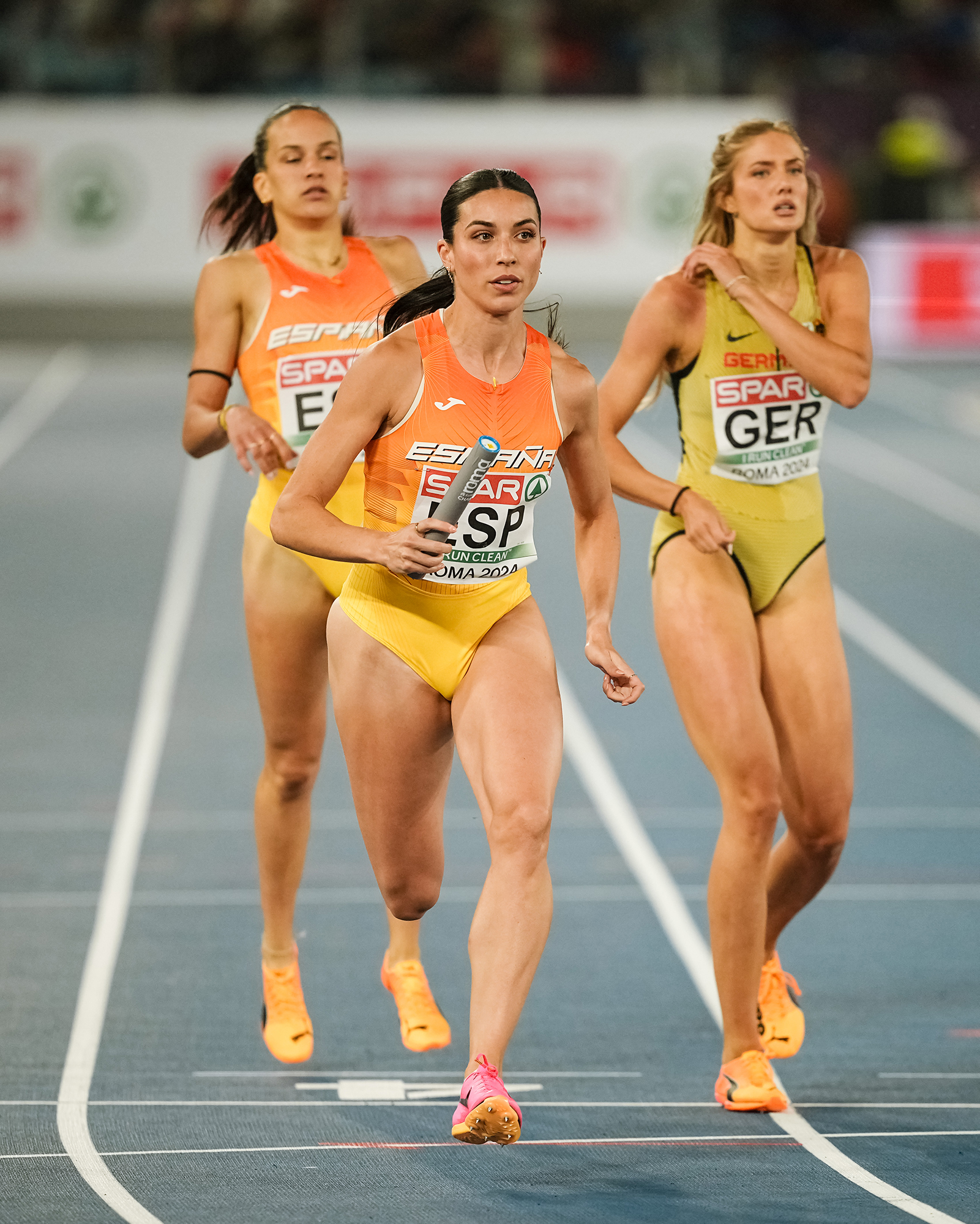 Women athletes running in a relay race.