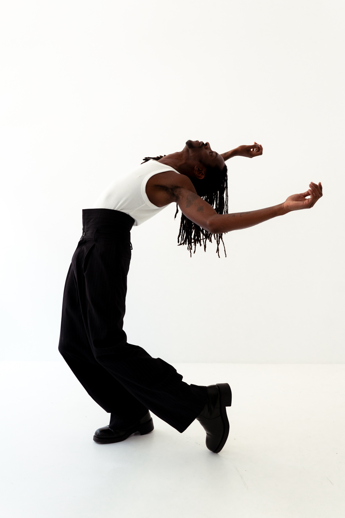 Person gracefully dancing in black and white outfit.