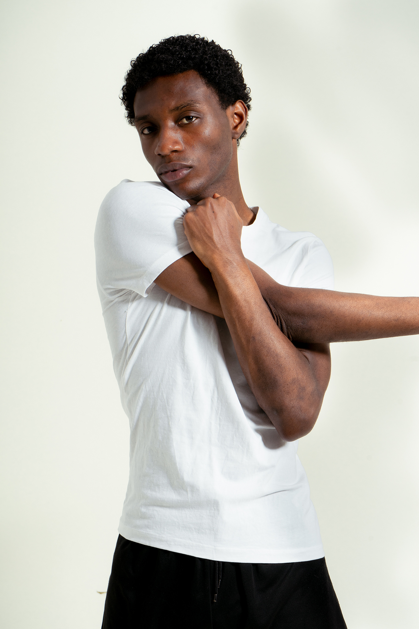 Person in white shirt stretching their arm.