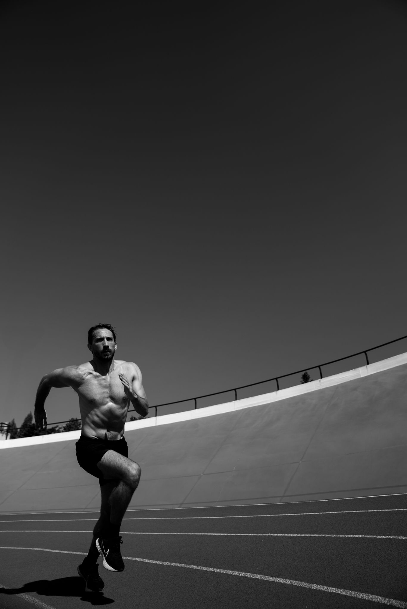 Athlete running on track, black and white photo.