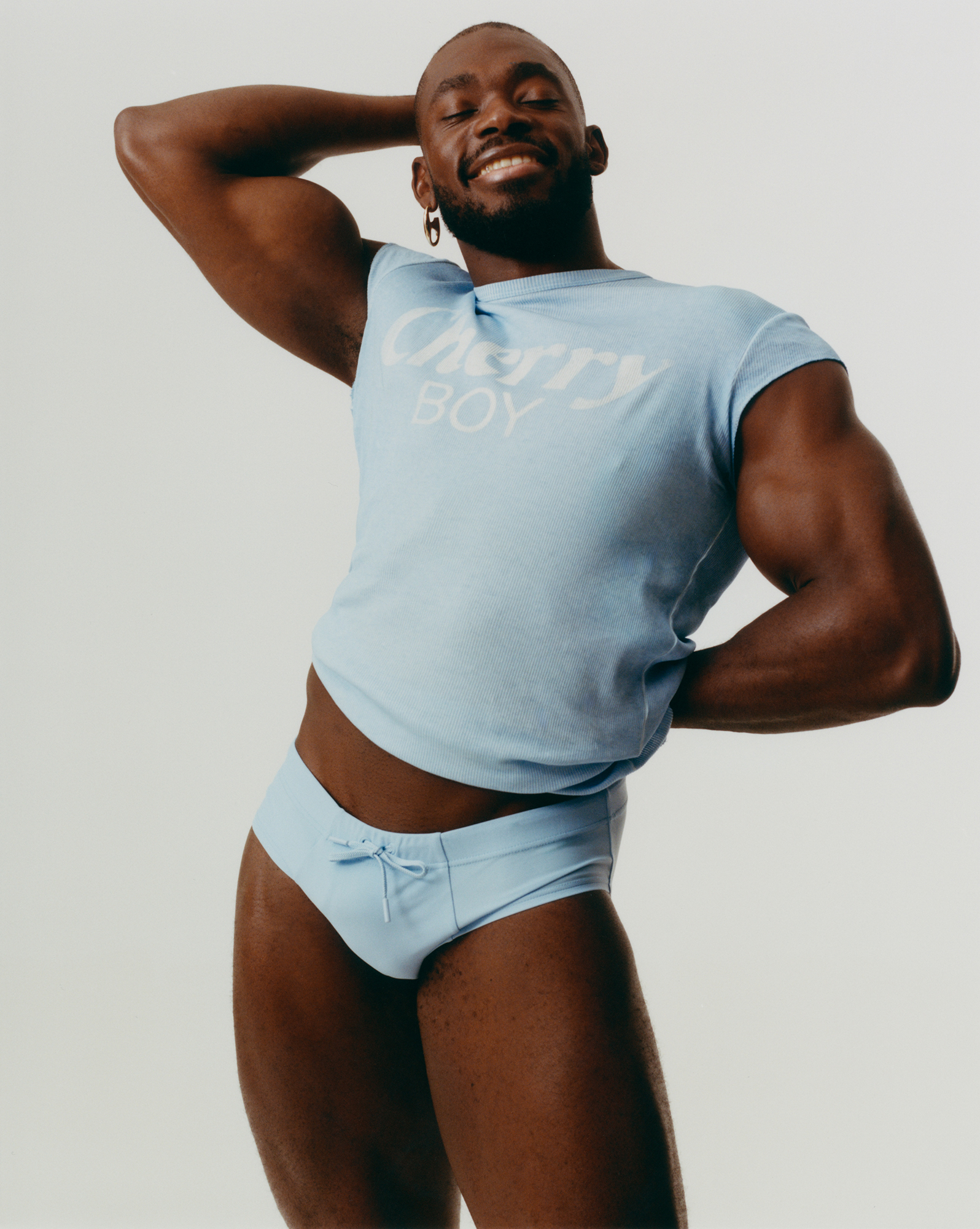 Person in blue shirt and briefs, posing confidently.