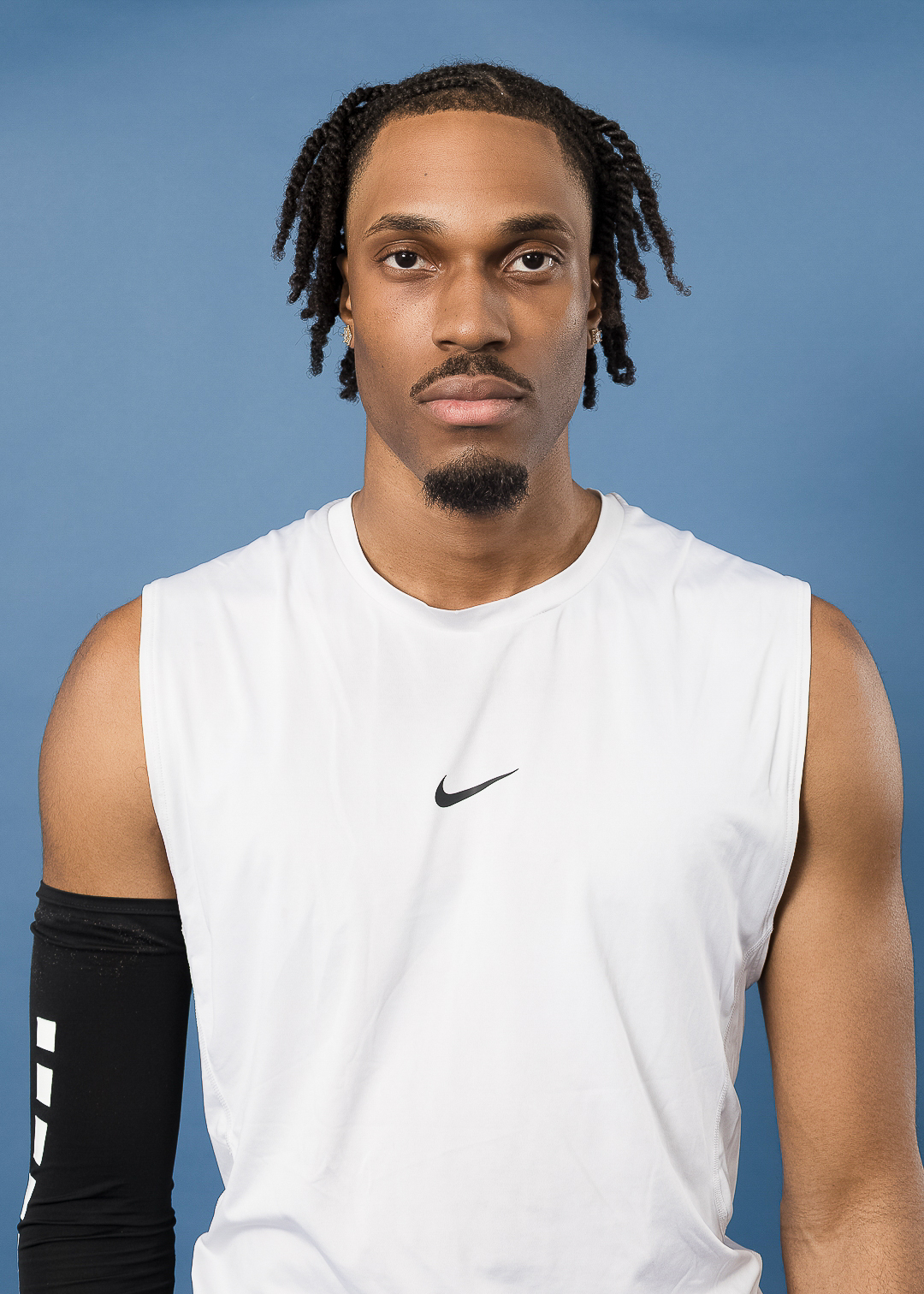 Man in white athletic shirt, blue background