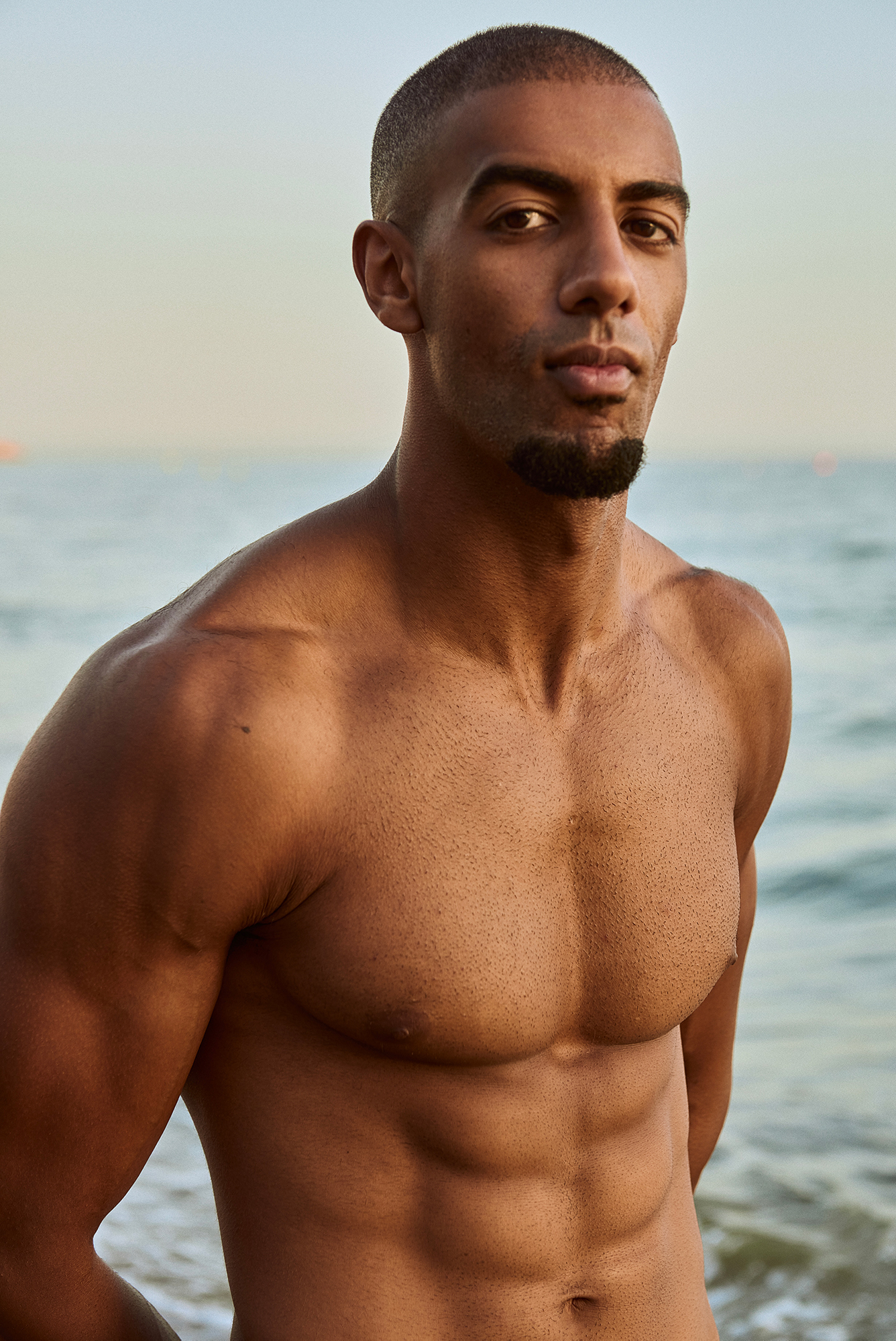 Man standing shirtless at the beach