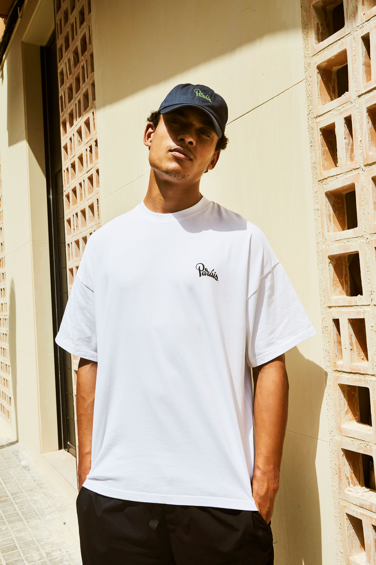 Man wearing Paradis t-shirt and cap outdoors