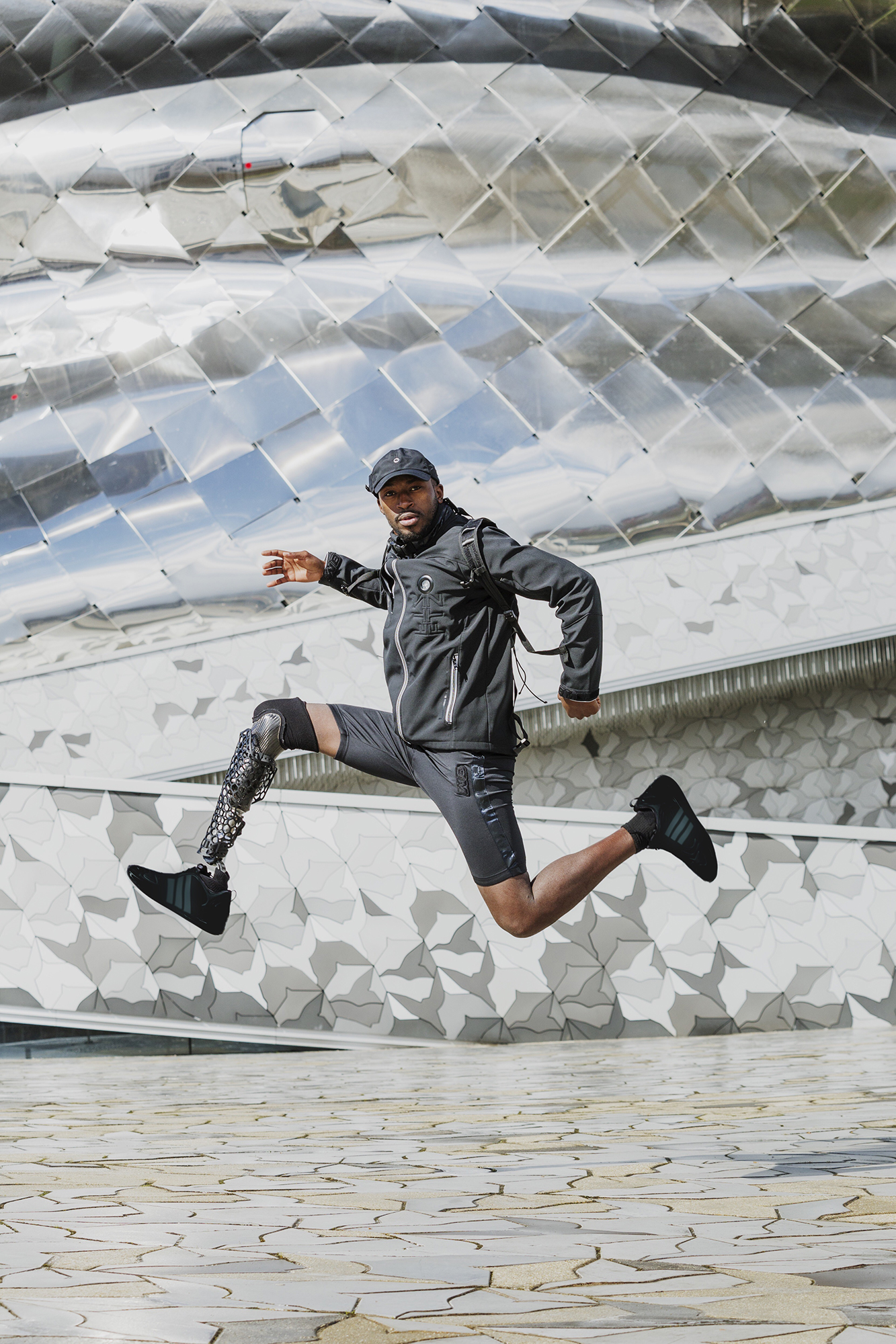 Person with prosthetic leg jumping energetically outdoors.