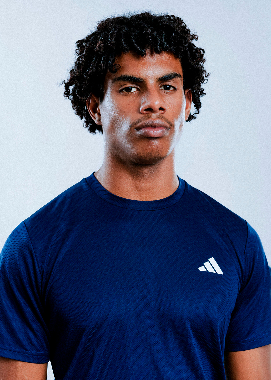 Person wearing blue Adidas shirt, neutral expression.