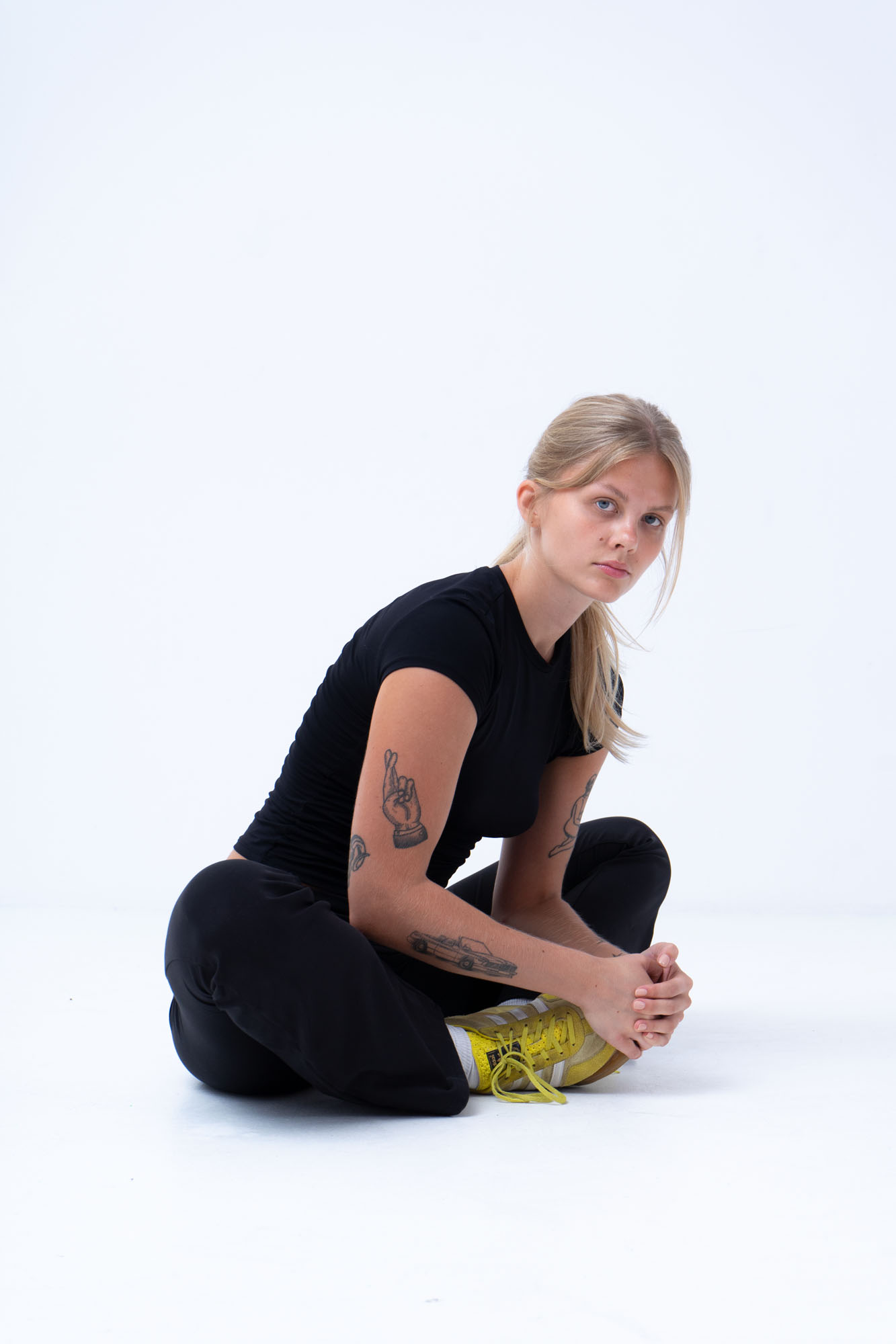 Person sitting cross-legged in a studio