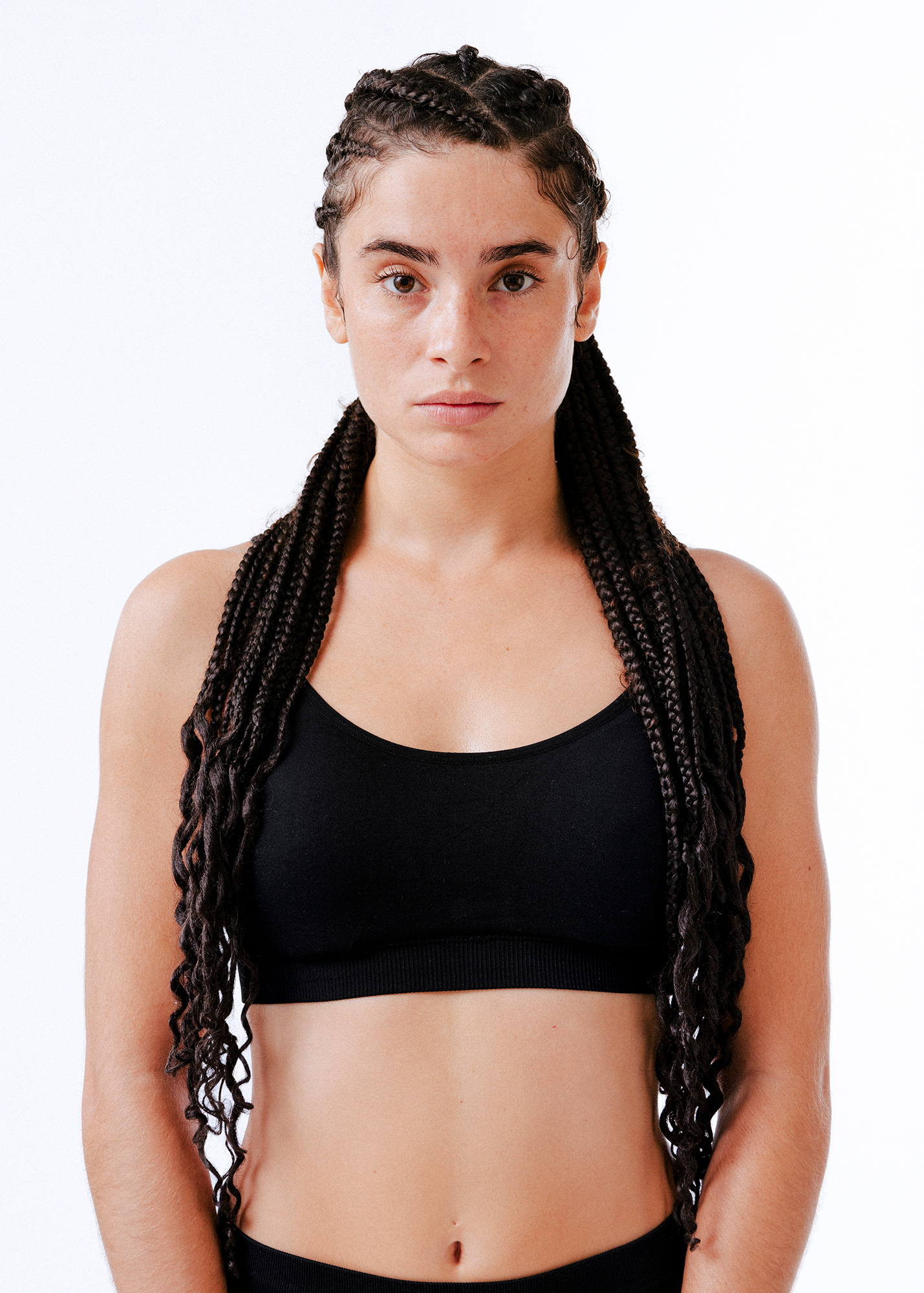 Person with cornrows wearing a black sports bra.