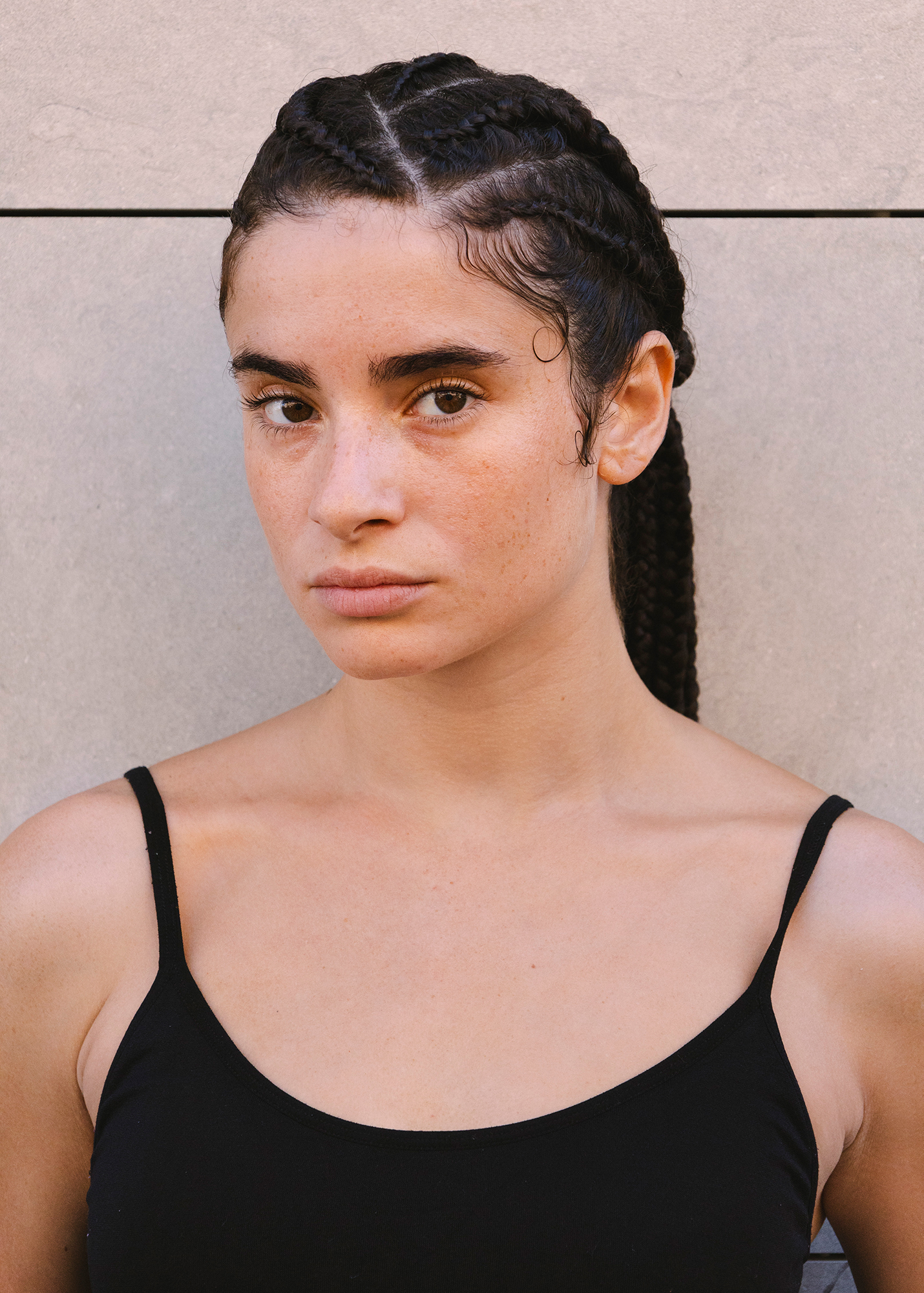 Woman with braided hair, neutral expression