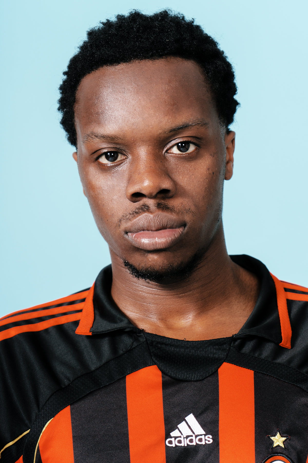 Soccer player in black and orange jersey.