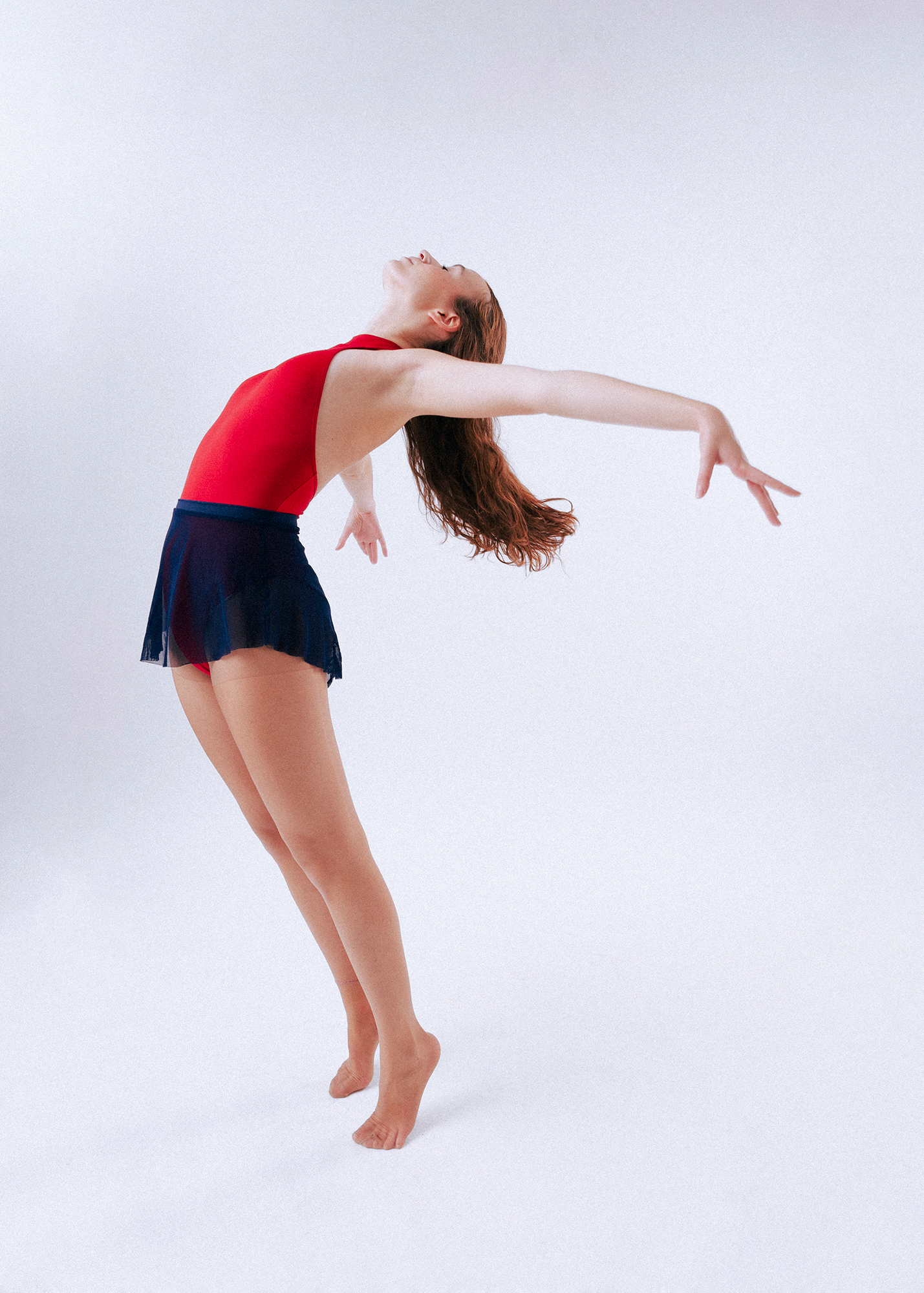 Dancer elegantly posing in red leotard