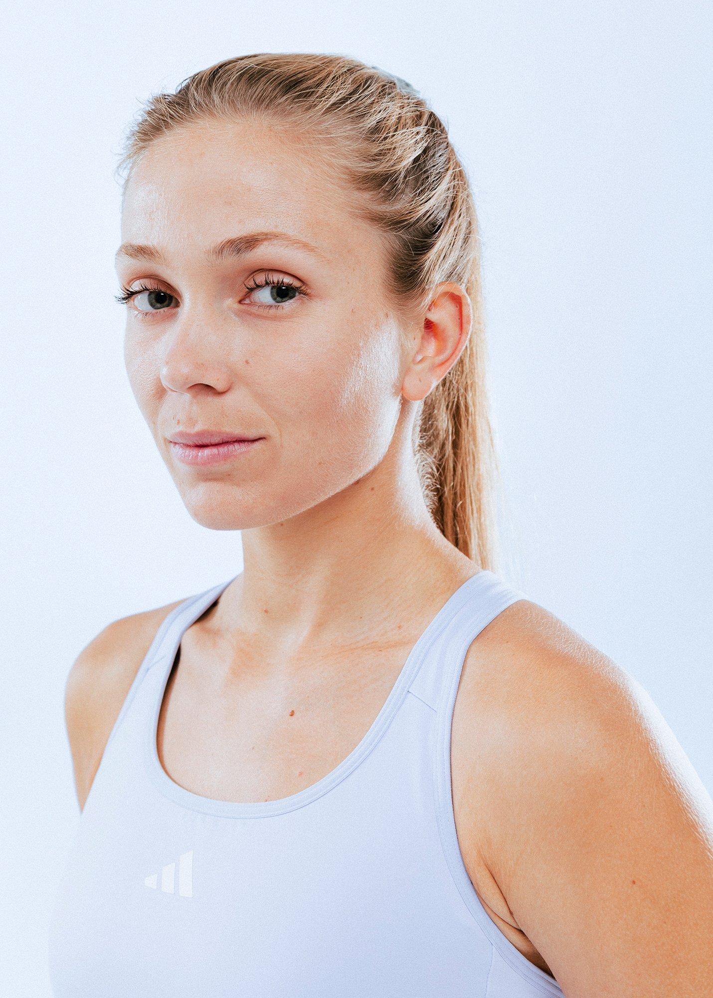 Woman in athletic tank top, light background