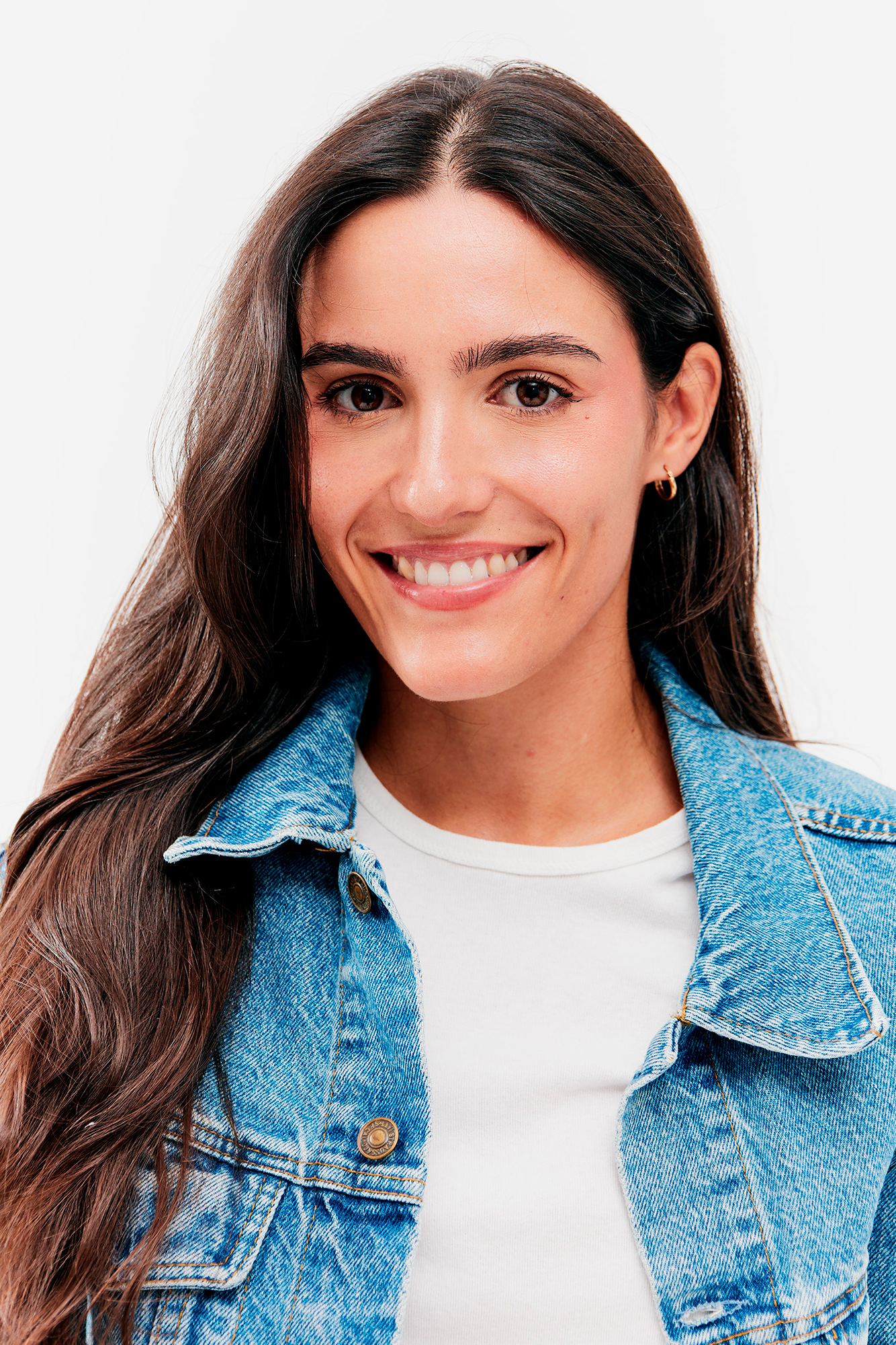 Smiling person in denim jacket and white shirt