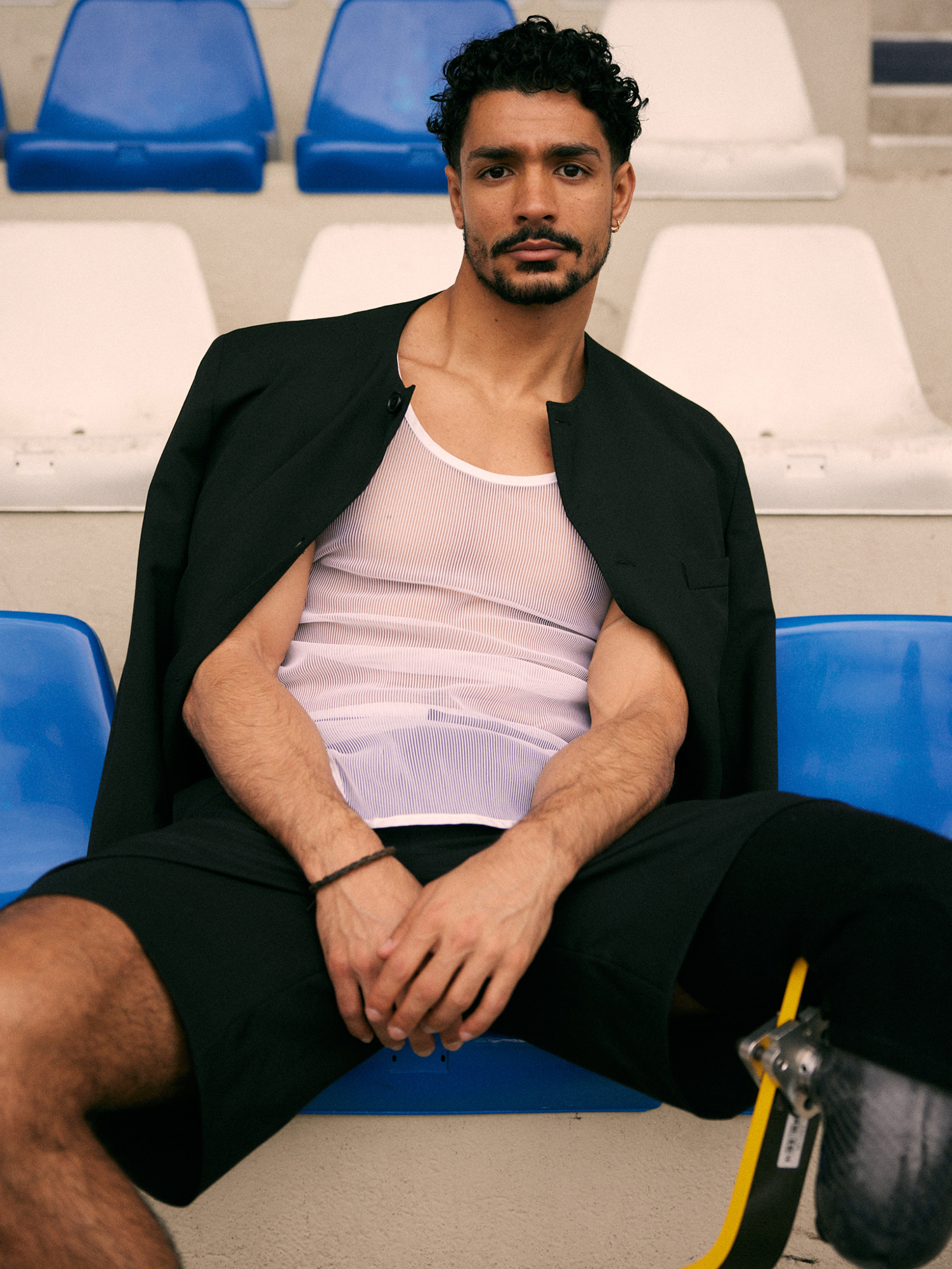 Person sitting on bleachers wearing sportswear.