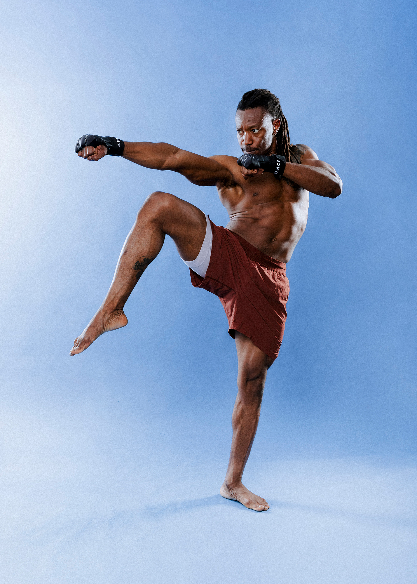 Martial artist performing high kick in studio.