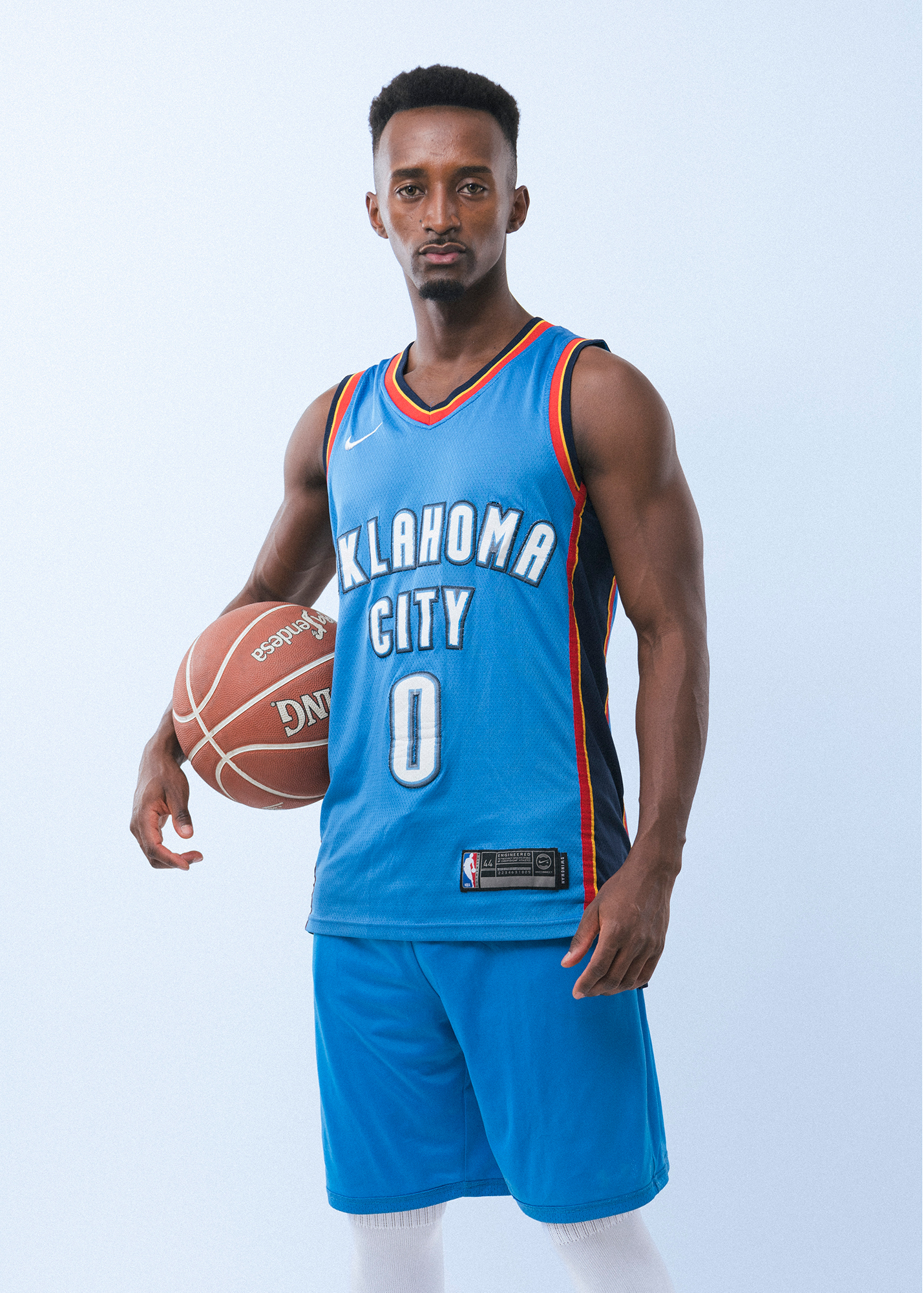 Basketball player in Oklahoma City jersey holding ball.