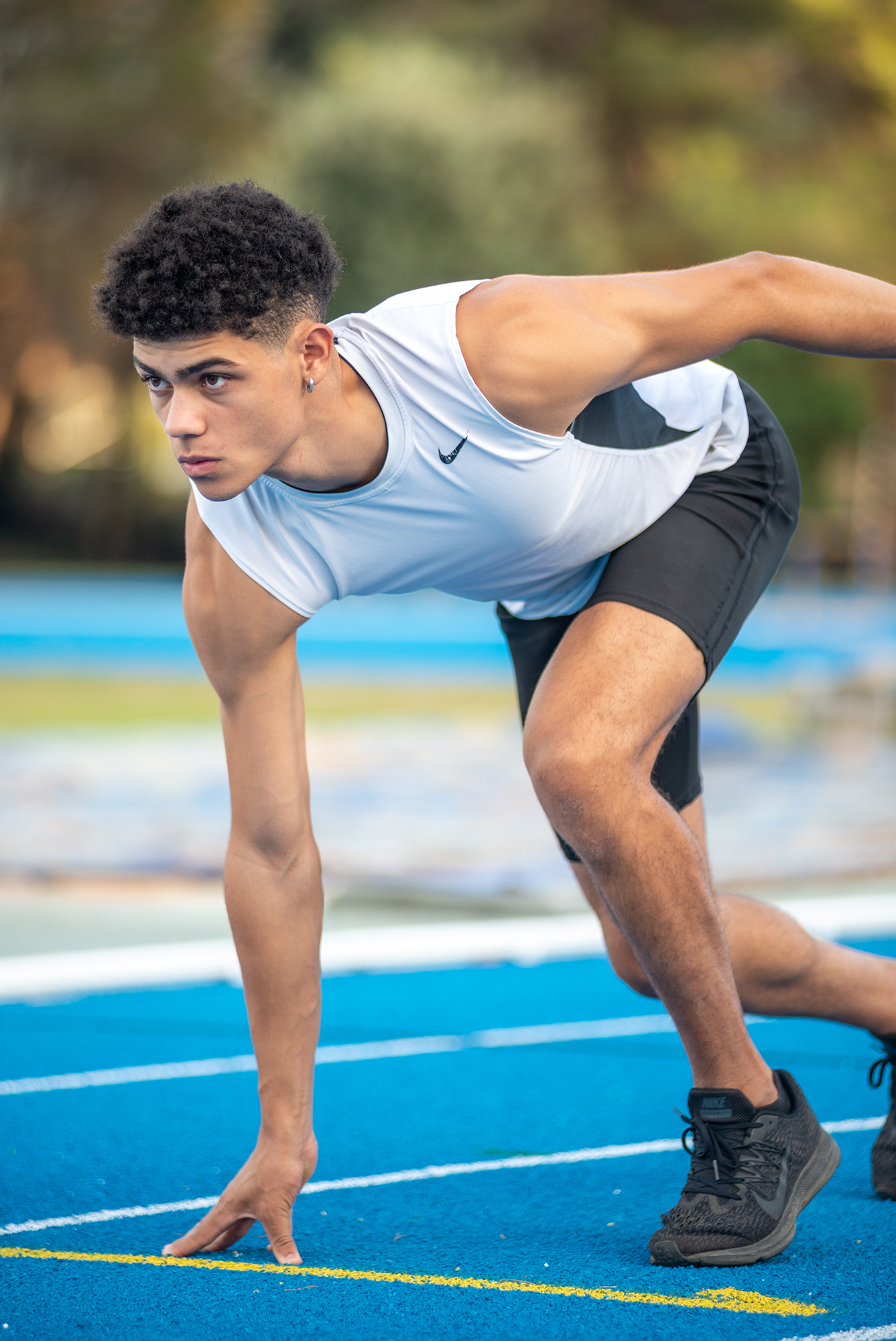 Athlete starting sprint on blue track