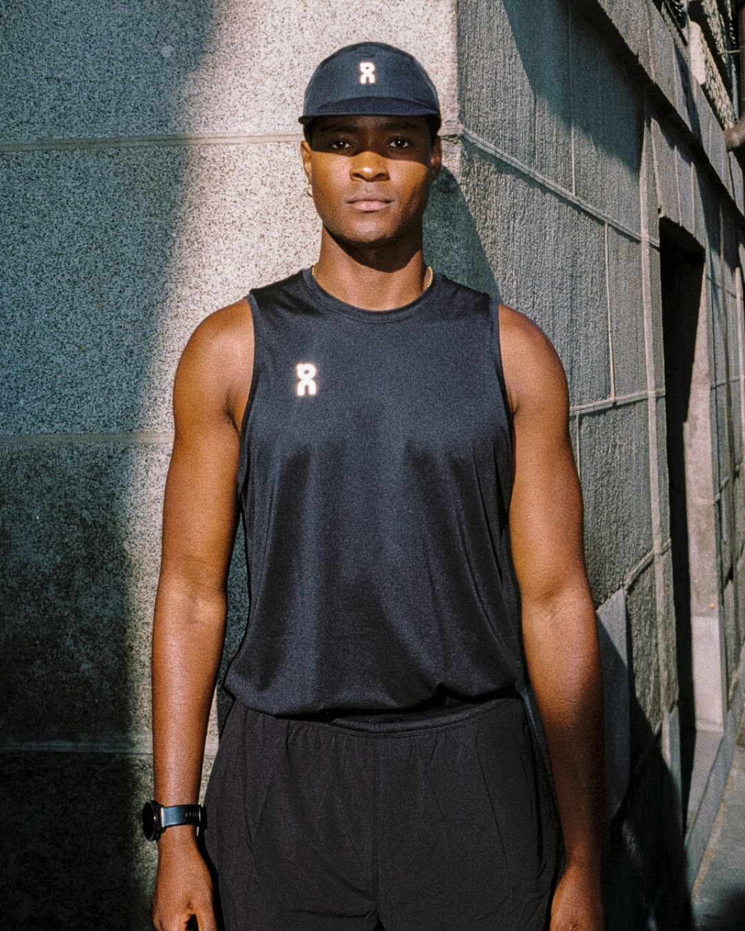 Athlete in black tank top, city background